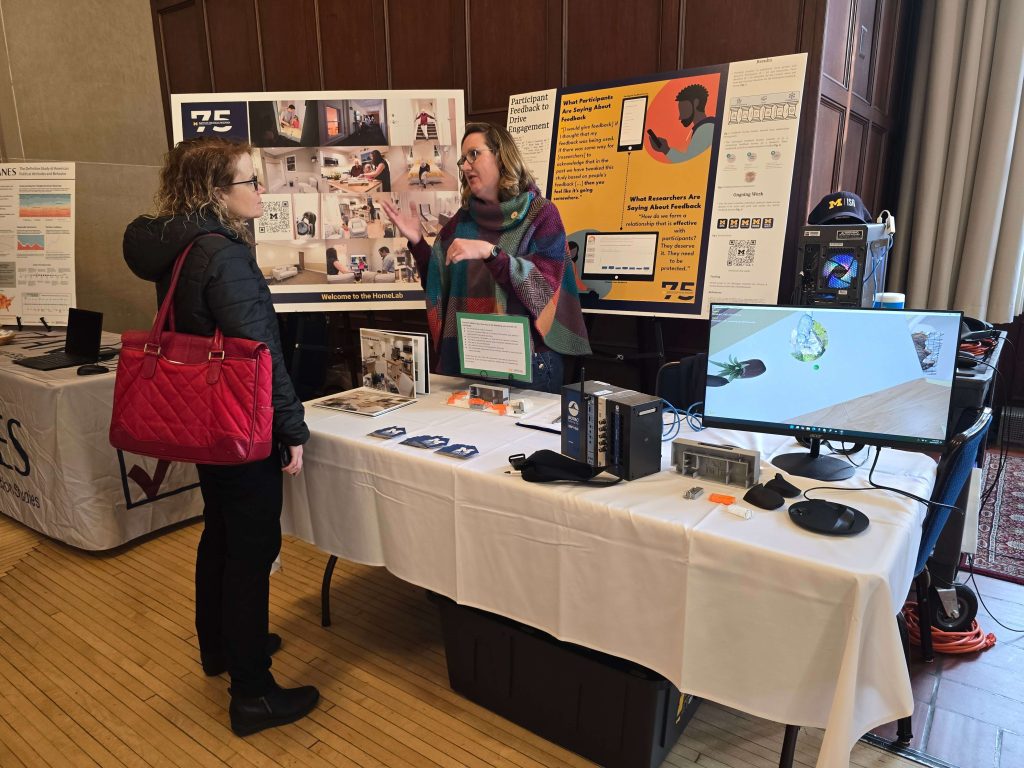 HomeLab staff member Donna Walter speaks with an attendee at the ISR 75th Anniversary Showcase